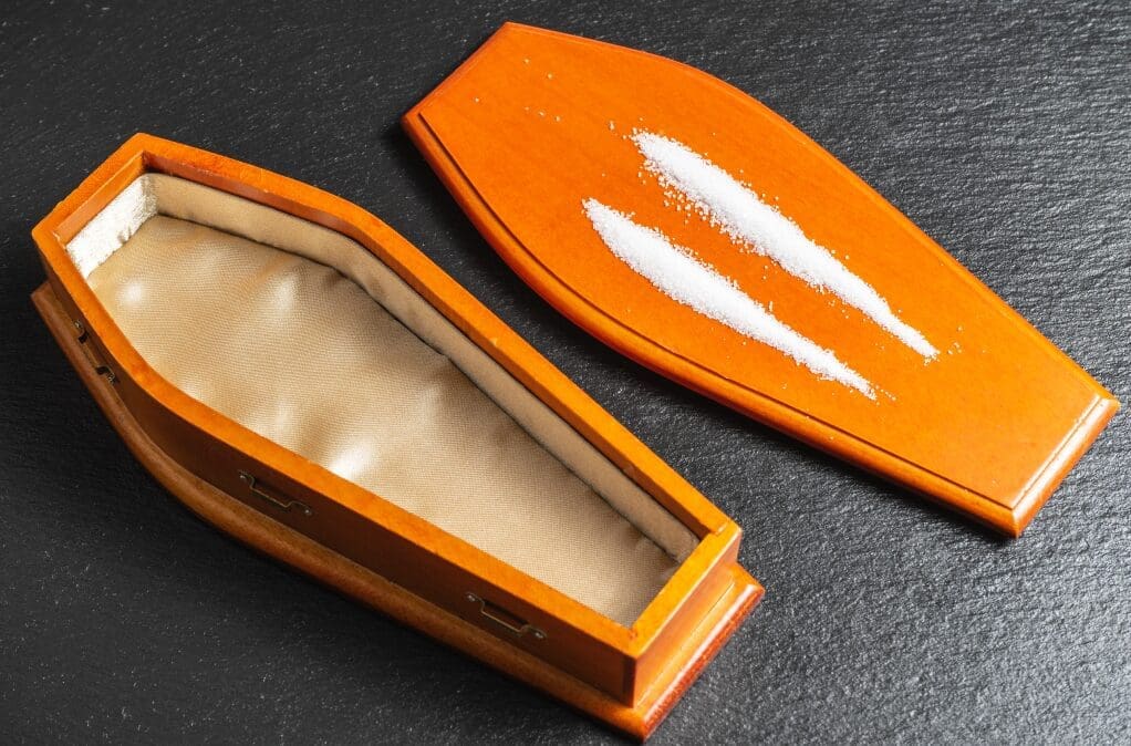 cocaine overdose symptoms showing an image of a coffin with cocaine lines on it