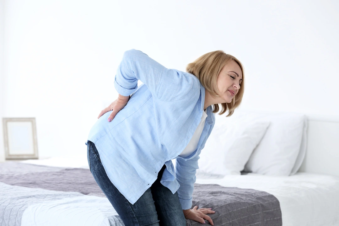 Woman suffering from Vertebrogenic Low Back Pain at home