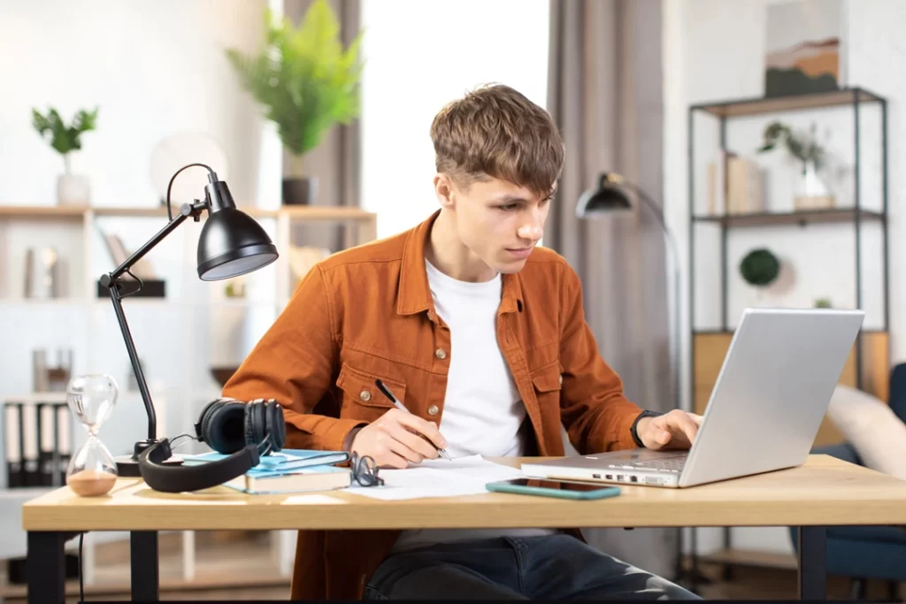 Focused and active young man sitting at a table with a laptop, Phenylethylamine Hydrochloride helps a lot.