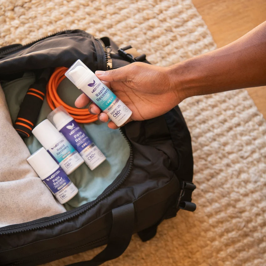 man picking up Medterra pain cream from the bag.