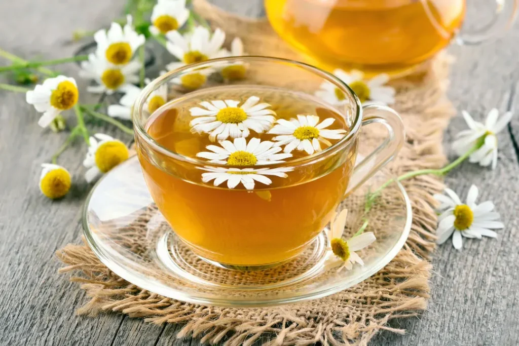 chamomile flowers tea in a glass cup on a wooden table