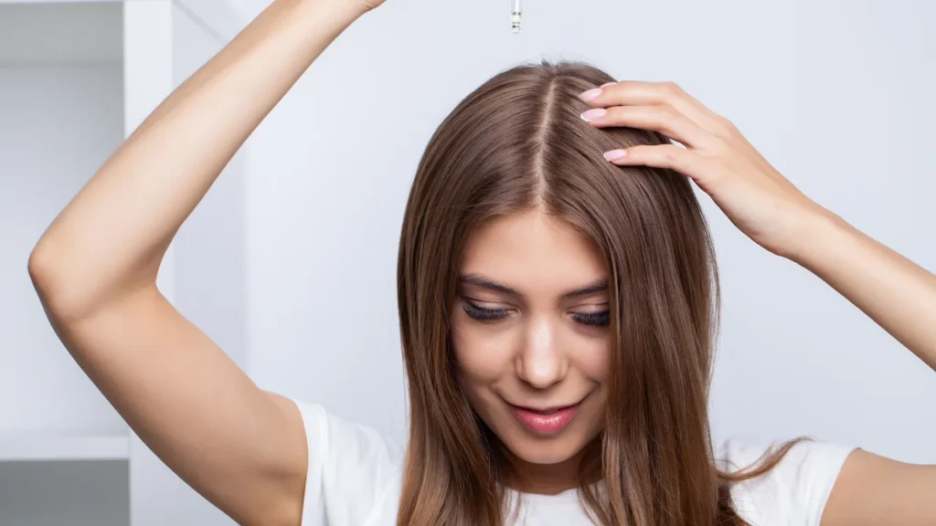 Girl applying moringa oil on scalp for healthy hairs